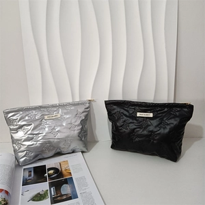Detailansicht der gesteppten PU-Kosmetiktasche mit Schmetterlingsmuster und Markenlabel