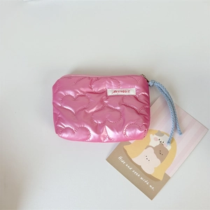 Close-up of pink quilted heart pouch with premium stitching and soft blue wrist strap