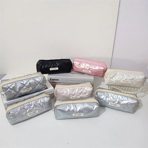 Close-up of quilted cosmetic bags with metallic finish and heart pattern stitching