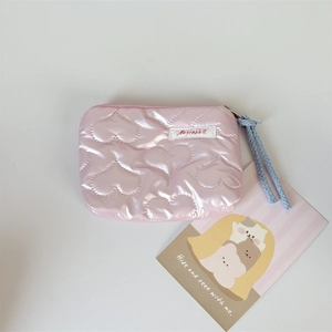 Detailed view of pink heart quilted PU cosmetic bag with blue zipper cord and brand label