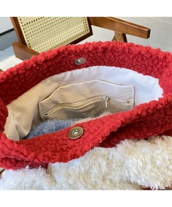Detail der roten Kunstfell-Beuteltasche mit cremefarbenem Futter und Reißverschlussfach
