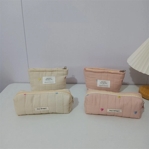 Detail of quilted makeup bags with colorful heart embroidery and secure zipper closure