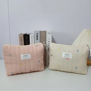 Quilted cosmetic bags with colorful heart embroidery and secure metal zipper detail
