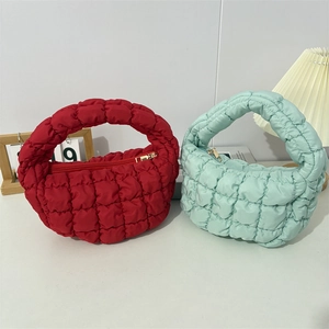 Close-up of quilted puffer handbags in red and mint green with bubble texture detail