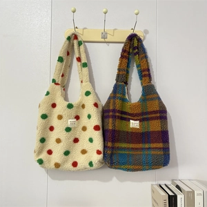 Dettaglio di borse tote in lana d'agnello con pois colorati e motivi scozzesi su ganci