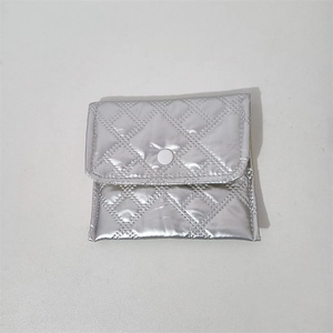 Detail of silver quilted PU pouch featuring diamond stitching and metal snap closure
