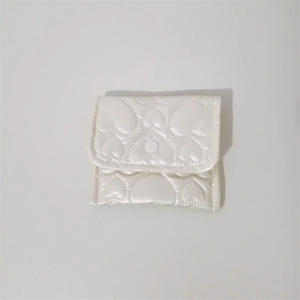 Detail of heart-quilted white PU leather mini storage bag with resin snap button