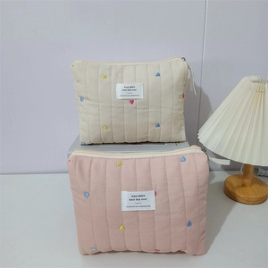 Close-up of quilted embroidery cosmetic bags with colorful heart patterns and fabric zipper