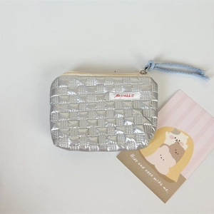 Close-up of metallic silver quilted cosmetic bag with woven blue zipper puller