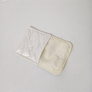 Detail view of cream white PU coin purse featuring heart quilting and snap closure