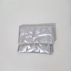 Close-up of silver quilted storage pouch with star patterns and metal button closure