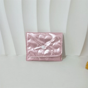 Macro detail of metallic pink PU leather pouch with heart quilted texture and snap button