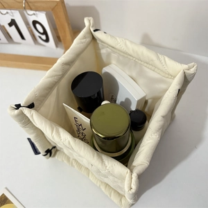 Quilted cream storage basket with diamond pattern holding skincare and makeup items