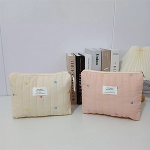 Quilted cotton makeup bag with colorful heart embroidery and secure zipper closure