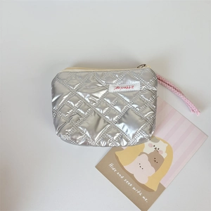 Close-up of a silver quilted mini pouch with pink lanyard and zipper closure