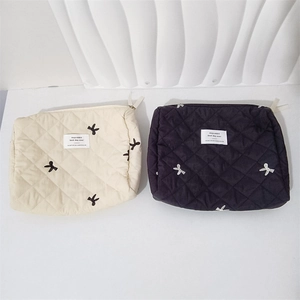 Close-up of quilted makeup bags with delicate bow embroidery and mayrabbit woven label
