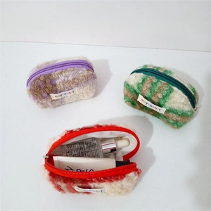 Macro detail of plush checkered shell pouches showing soft texture and functional storage