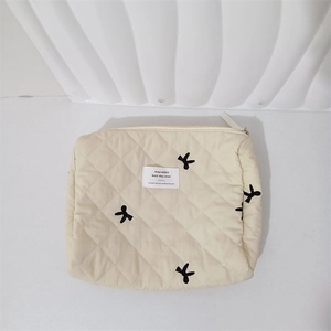 Close-up of beige quilted bag featuring rabbit embroidery and mayrabbit woven label