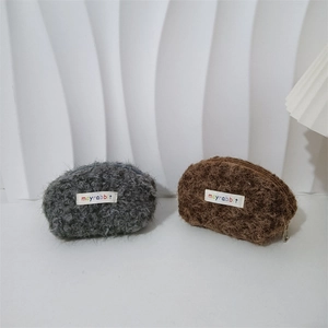 Dettagli di mini borse in lana di agnello peluche grigio e marrone, consistenza riccia