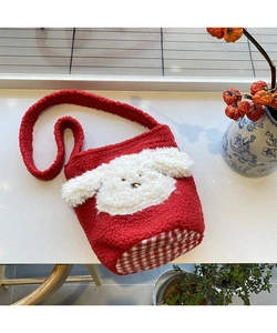 Detailansicht der roten Lammfell-Beuteltasche mit Welpen-Patch und Karomuster am Boden