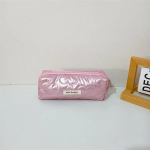 Detail of pink glossy pencil case with heart quilting and May Rabbit logo tag