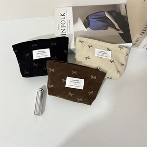 Détail de trousses à maquillage en velours côtelé avec motifs nœuds en trois couleurs