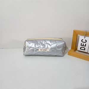 Silver quilted pouch with heart patterns and brand label for stationery or makeup