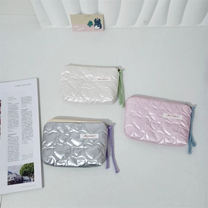Detail of heart quilted PU mini pouches in white silver and pink with braided zipper pulls