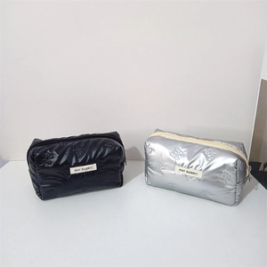 Close-up of quilted PU pouches with butterfly embossing in black and silver metallic finish