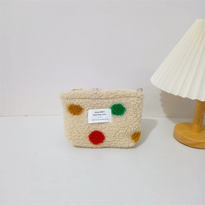 Close-up of fluffy sherpa lipstick bag with colorful polka dots and smooth zipper detail