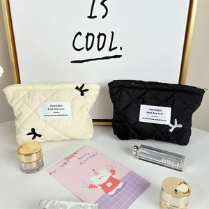 Detailed shot of quilted makeup bags with cute bow embroidery and zipper closure