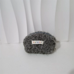 Dettaglio della borsa cosmetica in peluche grigio con etichetta mayrabbit e zip