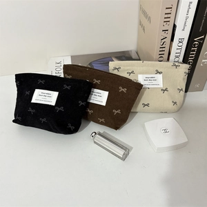 Détails des trousses à maquillage en velours côtelé avec motifs nœuds en noir et beige
