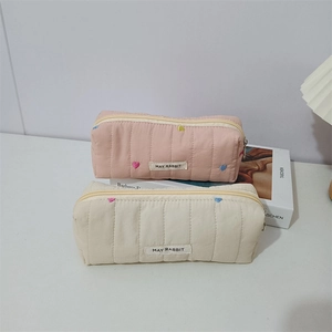 Detailed view of quilted makeup bags with colorful heart embroidery and secure zipper