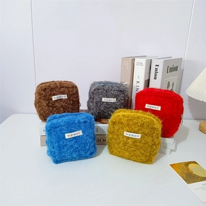 Nahaufnahme von fünf bunten Plüschtaschen mit weicher Textur und Reißverschluss