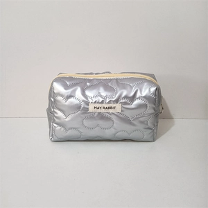 Close-up of heart-quilted silver PU makeup bag with zipper and May Rabbit brand label
