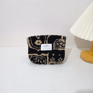 Detail of plush paisley cosmetic bag showing soft texture and high-quality zipper closure