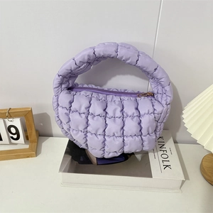 Close-up of light purple quilted cloud bag with padded square texture and zip closure