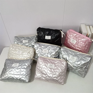 Detailed collection of quilted makeup bags in metallic silver, black, and pastel colors