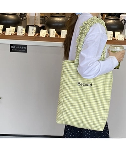 Dettaglio della borsa tote in tela a scacchi con ricamo Second e tracolla arricciata