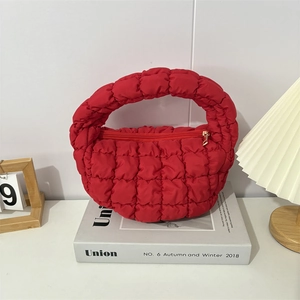 Detail of red quilted bubble handbag with metallic zipper and cloud texture finish