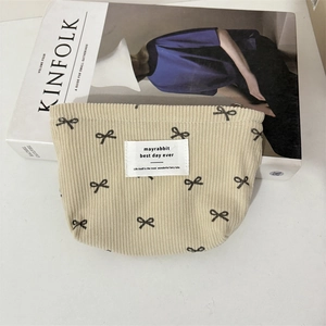Détail de la trousse de maquillage en velours côtelé avec broderie nœud papillon