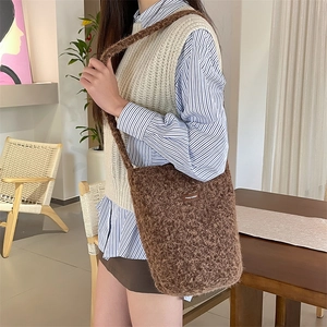 Gros plan sur la texture du sac seau en peluche marron avec étiquette cousue
