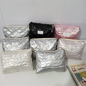 Detailed pile of quilted heart and star patterned cosmetic bags in various pearlescent colors