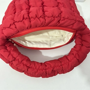 Detail view of red quilted cloud bag showing internal zipper pocket and lining