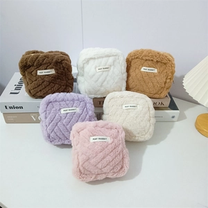 Macro shot of colorful plush knot mini pouches with woven texture and zipper details