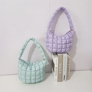 Detail of mint green and lavender purple puffer cloud bags with quilted bubble texture