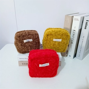 Drei Plüsch-Kosmetiktaschen in Braun, Gelb und Rot mit flauschiger Textur und Reißverschluss