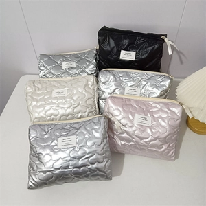 Quilted heart-pattern makeup bags in assorted metallic colors with zipper closure