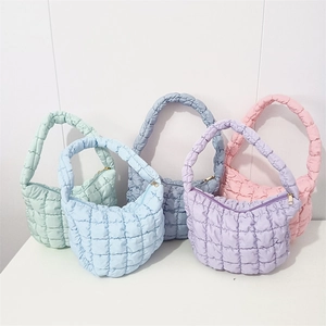 Detail view showing five pastel quilted puffer bags with square stitching and gold zippers
